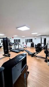 a gym with a lot of exercise bikes and a television at Aruana Azul 502 - Apto com AR, PISCINA, Varanda Integrada - Aluguel por Temporada in Aracaju