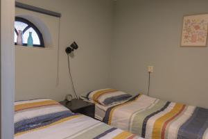 a bedroom with two beds and a window at Bij Ons Achter in Biggekerke