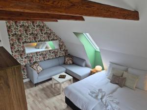 a attic bedroom with a bed and a couch at Søndergaarden in Øster Ulslev