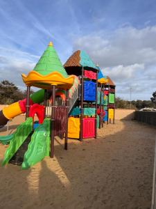 a row of playground equipment in the sand at mobil home spacieux climatisé sur camping sol a gogo in Saint-Hilaire-de-Riez