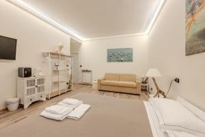 a white living room with a bed and a couch at Le Colonne Di San Luca Affittacamere in Genoa