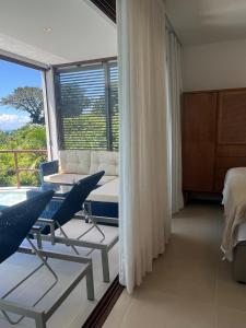 a living room with chairs and a couch and a window at Amerigo Exclusive in Morro de São Paulo