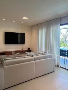a living room with couches and a flat screen tv at Amerigo Exclusive in Morro de São Paulo