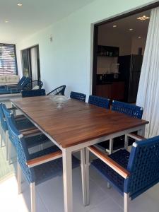 a large wooden table with blue chairs in a room at Amerigo Exclusive in Morro de São Paulo +45 photos