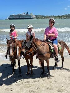 three girls are riding horses on the beach at City tours in Colorado