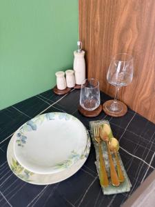 a table with a plate and wine glasses on it at 13 Daily apartments in Tirana