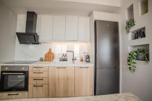 a kitchen with white cabinets and a stainless steel refrigerator at Golden Horizon seafront in Goúdhouros