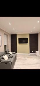 a living room with a couch and a flat screen tv at The Arch apartment in Bangor