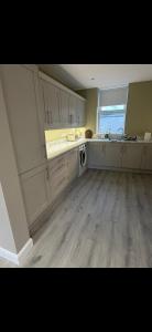 a kitchen with white cabinets and a sink and a dishwasher at The Arch apartment in Bangor +7 photos