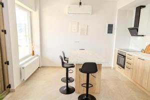 a kitchen with a table and two stools at Golden Horizon seafront in Goúdhouros