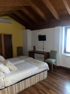 a bedroom with a bed and a desk and a television at Casa de La Consentida in Elciego