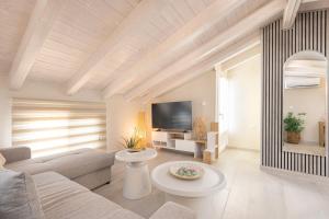a living room with a couch and a tv at Pythagoreio Blue Street Upper Floor Apartment in Pythagoreio