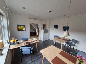a living room with wooden tables and chairs at Søndergaarden in Øster Ulslev +21 photos