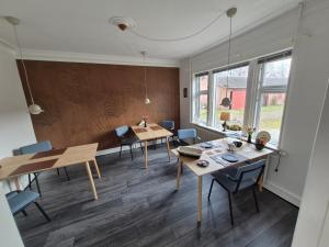 a room with two tables and chairs and a dining room at Søndergaarden in Øster Ulslev