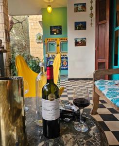 a bottle of wine and a glass on a table at Villa La Drianké in Dakar +25 photos