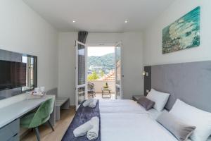a bedroom with two beds and a desk and a window at Art Hotel Dubrovnik in Dubrovnik