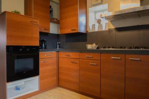 a kitchen with wooden cabinets and a stove top oven at Bij Ons Achter in Biggekerke
