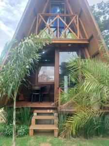 a wooden cabin with a staircase leading to the front of it at Chalé Garças in Chapada dos Guimarães