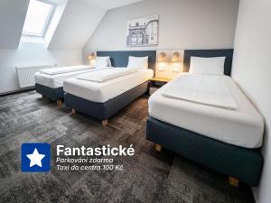 two beds in a hotel room with two bedsvisor at Wellness penzion a restaurace U Gigantu in Pilsen