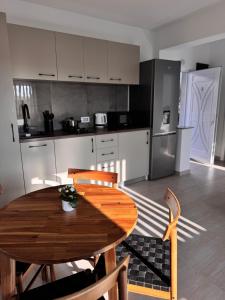 a kitchen with a wooden table and chairs and a kitchen with a refrigerator at Studio in 2 Mai,Quiet,Spacious,Garden,Separate Bedroom - Donilads Properties - Home Everywhere in 2 Mai