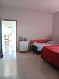 a bedroom with two beds and a table with a chair at Casa PA parque das aguas in Bonito
