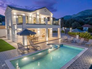 a house with a swimming pool in front of it at Villa La Bianca in Marketáta