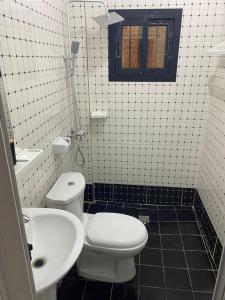 a bathroom with a white toilet and a sink at VVVIP lita Résidence in Ekoumdoum +17 photos