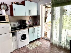 a kitchen with a washing machine and a washer at Su da noi in San Dorligo della Valle