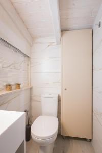 a white bathroom with a toilet and a sink at Pythagoreio Blue Street Upper Floor Apartment in Pythagoreio +15 photos