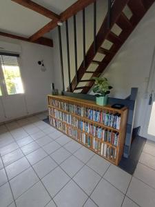 a room with a book shelf filled with books at Une parenthése à la campagne in Cirey