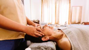 a woman getting her face massage at a spa at Hotel Willow Banks in Shimla