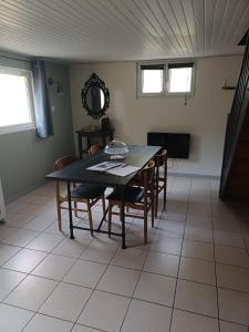 a dining room with a table with chairs and a mirror at Une parenthése à la campagne in Cirey