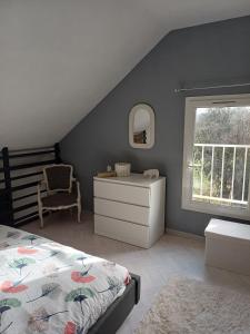a bedroom with a bed and a dresser and a window at Une parenthése à la campagne in Cirey