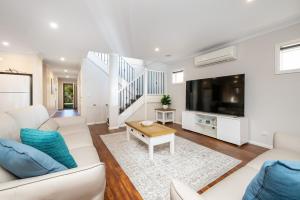 a living room with a white couch and a tv at Parkside Breeze in Rosebud in Rosebud