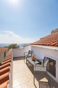 a patio with two chairs and a table on a house at Pythagoreio Blue Street Upper Floor Apartment in Pythagoreio