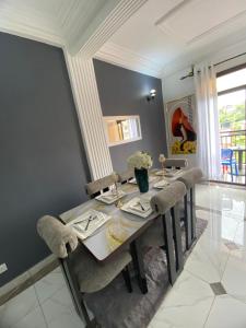 a dining room with a table and some chairs at VVVIP lita Résidence in Ekoumdoum