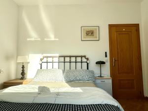 a bedroom with a bed and a wooden door at VUT Plaza del Rastro in Ávila
