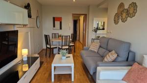 a living room with a couch and a table at Apartamento Sandy - wifi, ascensor, vistas al Mar,Amplio y Acogedor in Laxe