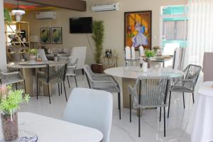 a dining room with tables and chairs and a tv at Onyx luxury rd in La Romana