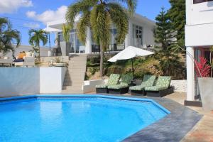 a swimming pool with chairs and an umbrella at Onyx luxury rd in La Romana