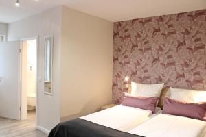 a bedroom with a bed with a floral wallpaper at Weingut Markus Junglen in Kröv