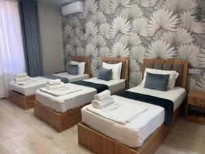 a bedroom with two beds and a wall with flowers at Amir Mumtoz Boutique hotel in Bukhara +38 photos