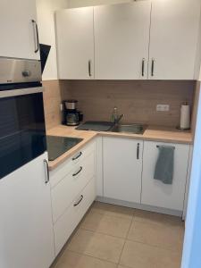 a kitchen with white cabinets and a sink at Klein aber fein in Gaimersheim