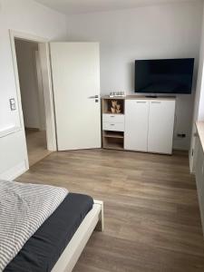 a bedroom with a bed and a flat screen tv at Klein aber fein in Gaimersheim