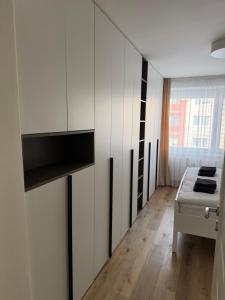 a kitchen with white cabinets and a table in a room at 2 izbový moderný byt centrum in Veľký Krtíš