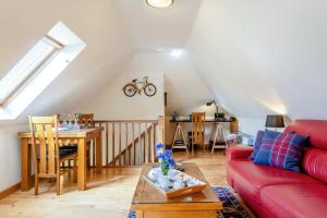 a living room with a red couch and a table at 1 Bed in Piltdown oc-t36330 in Fletching