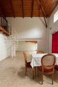 a dining room with a table and chairs and a staircase at Arcadia entre cipreses in Pueblo Esther