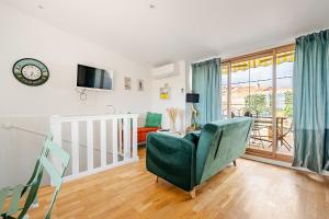 a living room with a green chair and a couch at Duplex 2chambres avec Terrasse Centre Historique in Fréjus