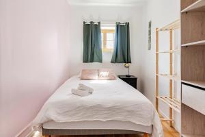 a bedroom with a white bed with green curtains at Duplex 2chambres avec Terrasse Centre Historique in Fréjus