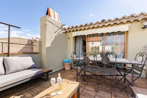 a patio with a table and chairs and a couch at Duplex 2chambres avec Terrasse Centre Historique in Fréjus
